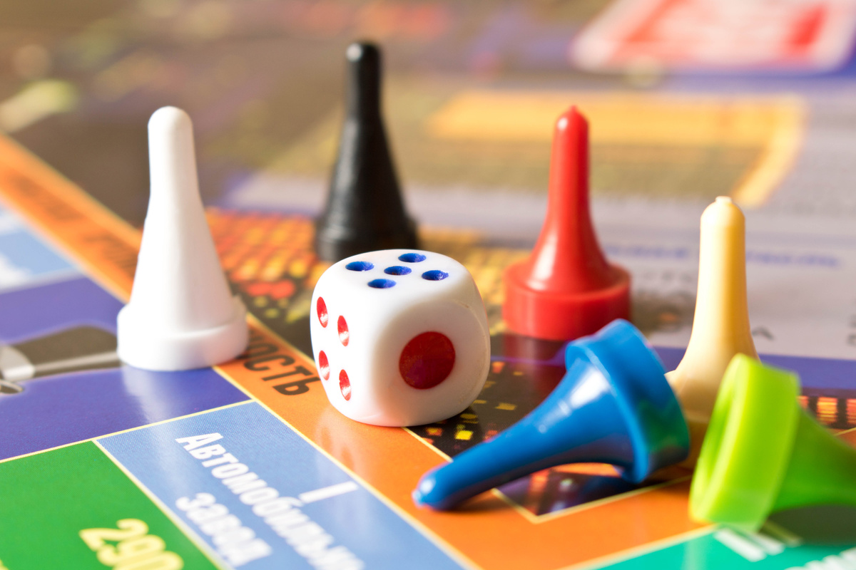 Multi-colored game chips with dice on the playing board. Board game